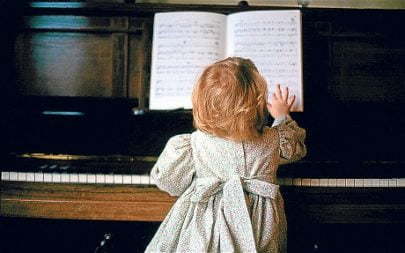 Young girl playing the piano, UK...B5T28D Young girl playing the piano, UK