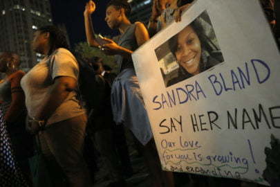 A demonstrator holds a Sandra Bland sign during a vigil, Tuesday evening, July 28, 2015, near the DuSable Bridge on Michigan Ave. in Chicago. Bland died in a Texas county jail after the traffic stop for failing to use a turn signal escalated into a physical confrontation. Authorities have said Bland hanged herself, a finding her family disputes. The death has garnered national attention amid increased scrutiny of police treatment of blacks in the wake of several high-profile police-involved deaths. (AP Photo/Christian K. Lee)